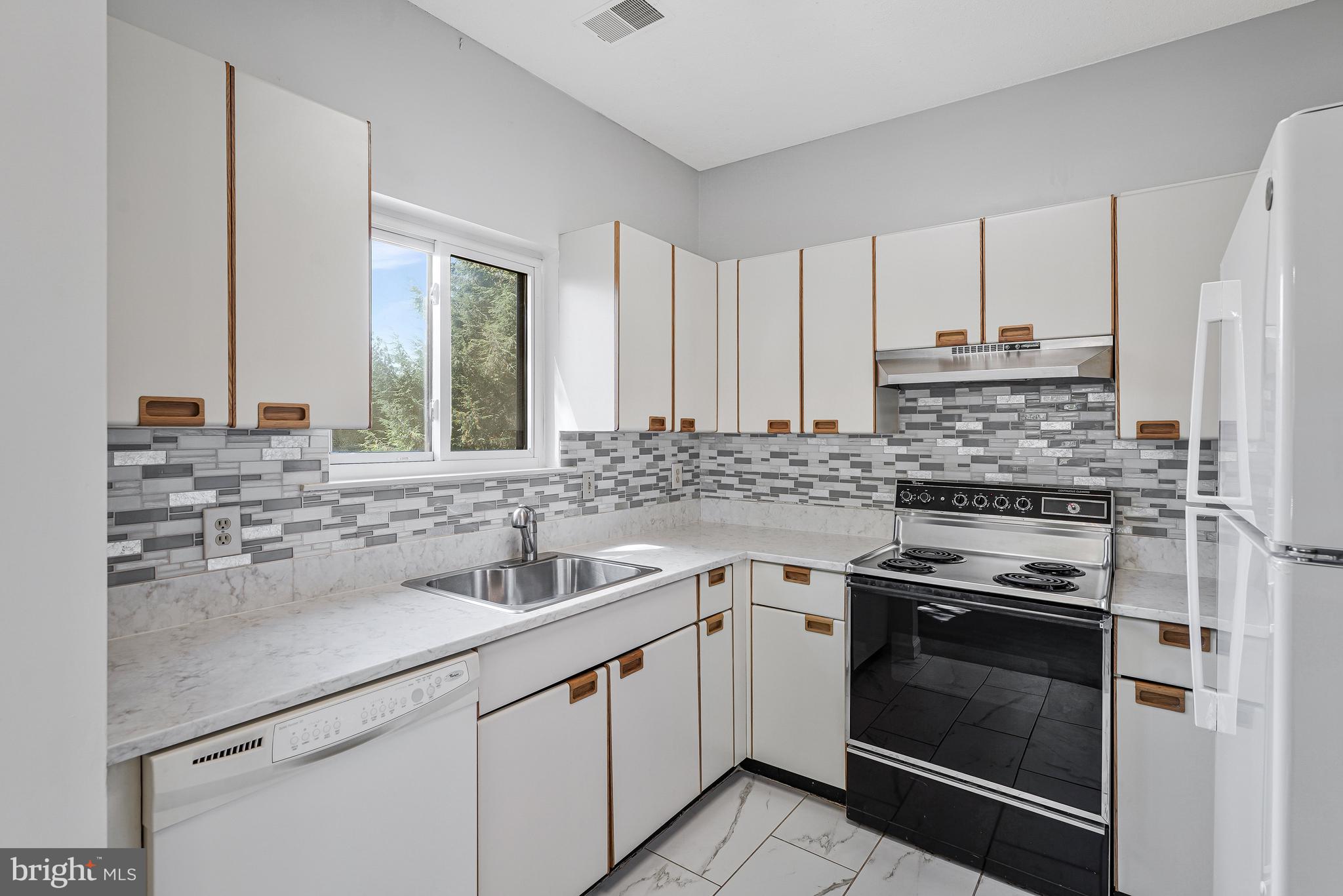 1964 Villaridge Drive Reston, VA 20191 - Photo 12 of 27 a kitchen with stainless steel appliances granite countertop a sink stove and refrigerator