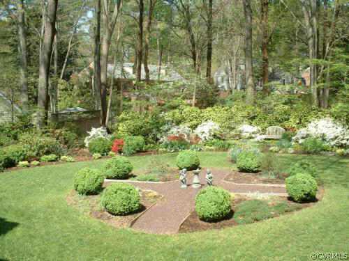 7606 Cheshire Road Richmond, VA 23229 - Photo 4 of 5 a view of a garden with plants and a bench