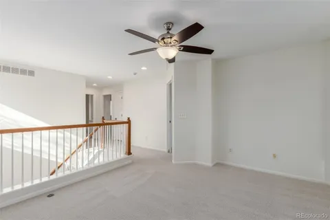 a view of a hallway with a ceiling fan