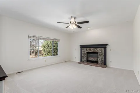 an empty room with fireplace and fan