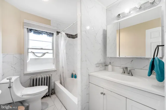 a bathroom with a sink a toilet a mirror a bathtub and shower