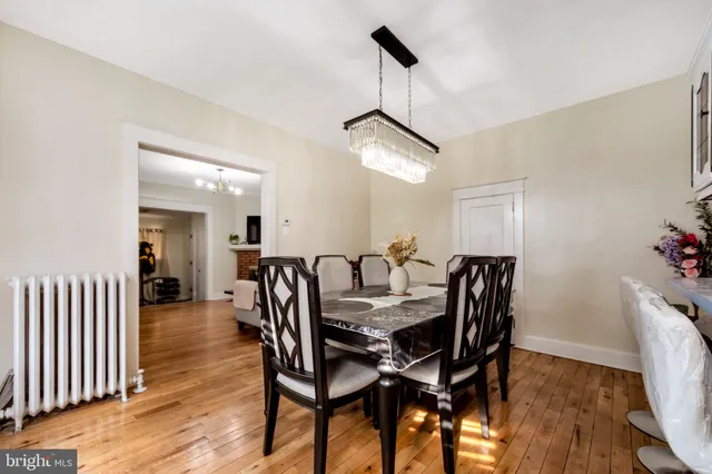 a view of a dining room and livingroom with furniture wooden floor a chandelier