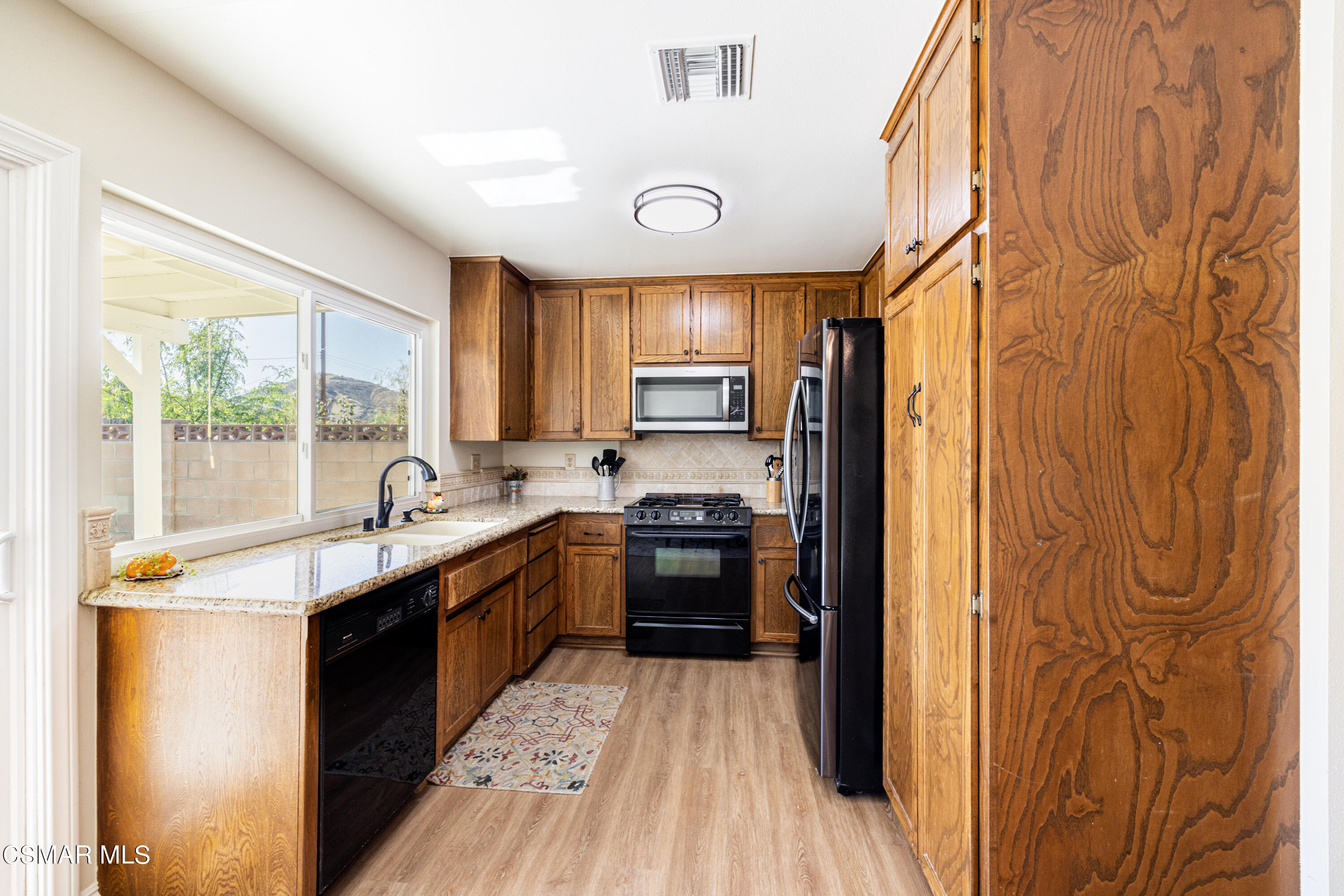 5708 Damon Street Simi Valley, CA 93063 - Photo 8 of 26 a kitchen with stainless steel appliances granite countertop a sink and wooden cabinets