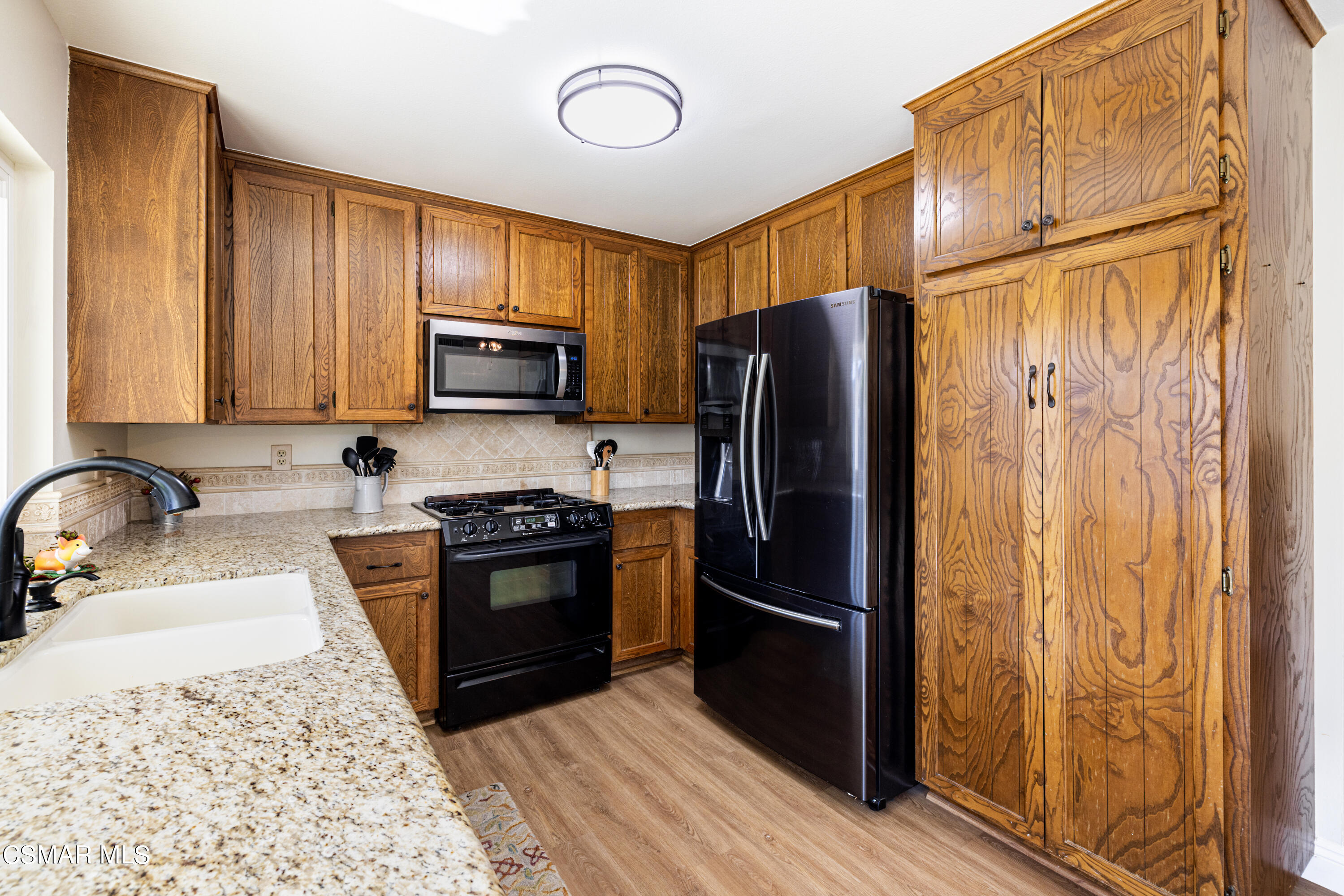 5708 Damon Street Simi Valley, CA 93063 - Photo 9 of 26 a kitchen with granite countertop wooden cabinets and stainless steel appliances