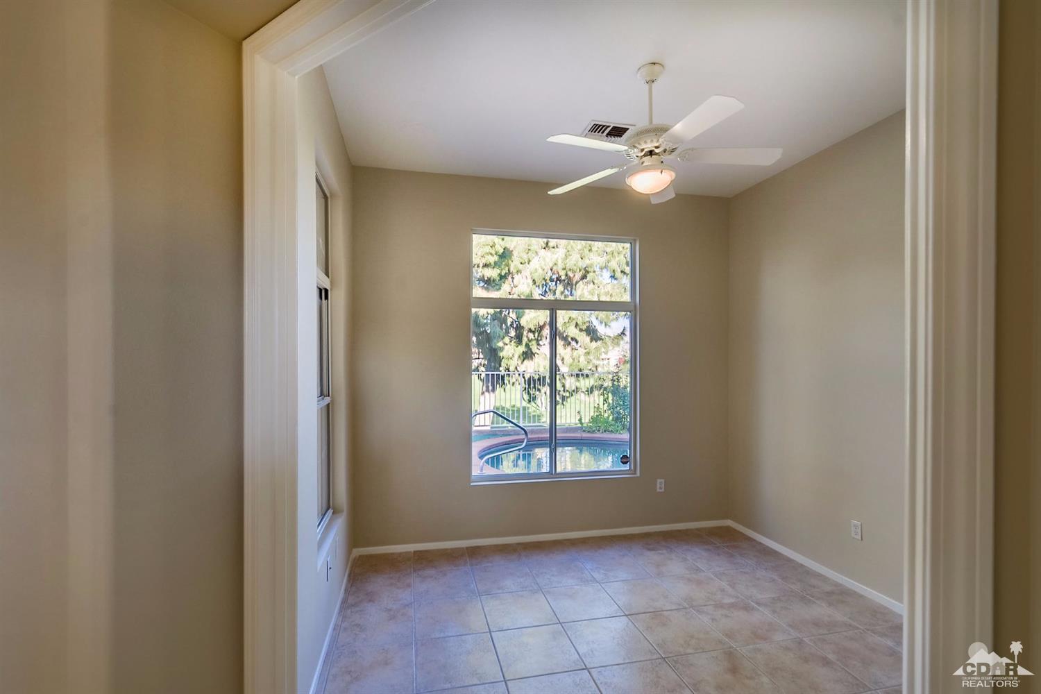 39515 Manorgate Road Palm Desert, CA 92211 - Photo 16 of 42 a view of an empty room with window and chandelier fan