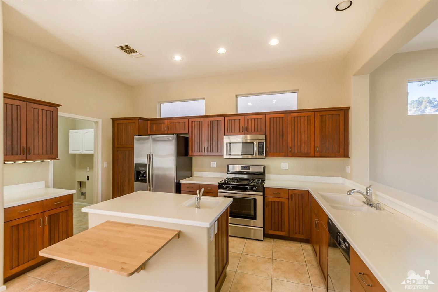 39515 Manorgate Road Palm Desert, CA 92211 - Photo 17 of 42 a kitchen with stainless steel appliances a sink stove and refrigerator