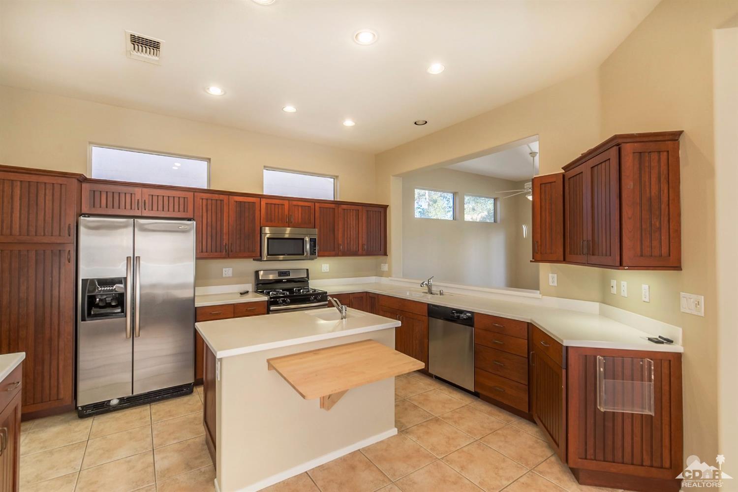 39515 Manorgate Road Palm Desert, CA 92211 - Photo 18 of 42 a kitchen with stainless steel appliances granite countertop a refrigerator sink and cabinets