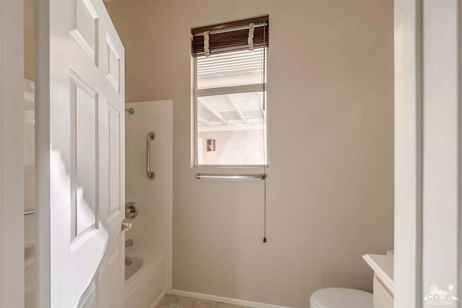39515 Manorgate Road Palm Desert, CA 92211 - Photo 30 of 42 a bathroom with a window and toilet