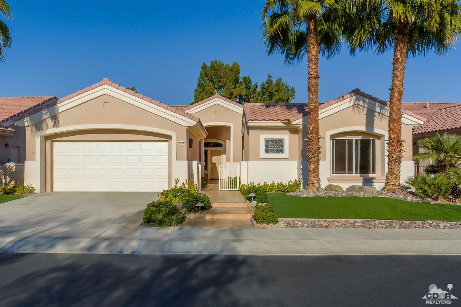 39515 Manorgate Road Palm Desert, CA 92211 - Photo 5 of 42 a front view of a house with a garden and trees