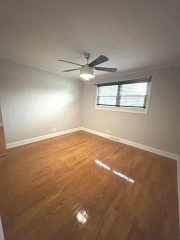 an empty room with a window and a ceiling fan