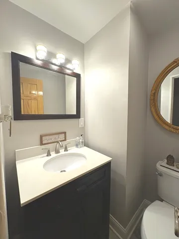 a bathroom with a toilet sink and mirror