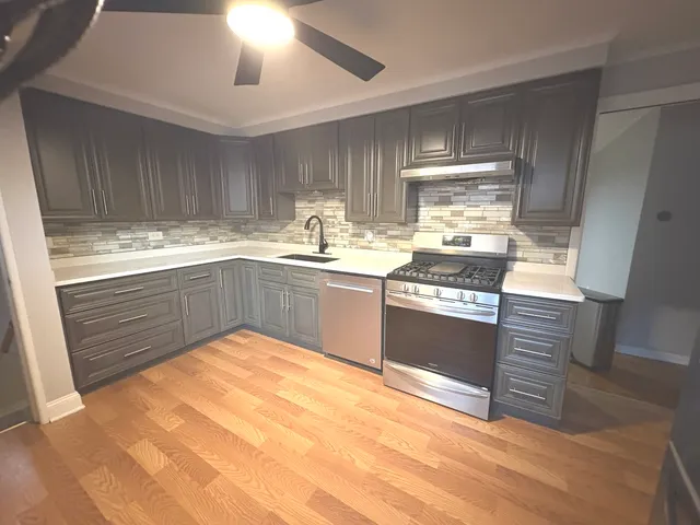 a kitchen with stainless steel appliances granite countertop a sink stove and refrigerator