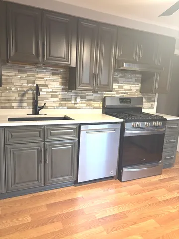 a kitchen with stainless steel appliances granite countertop a stove a sink and a microwave