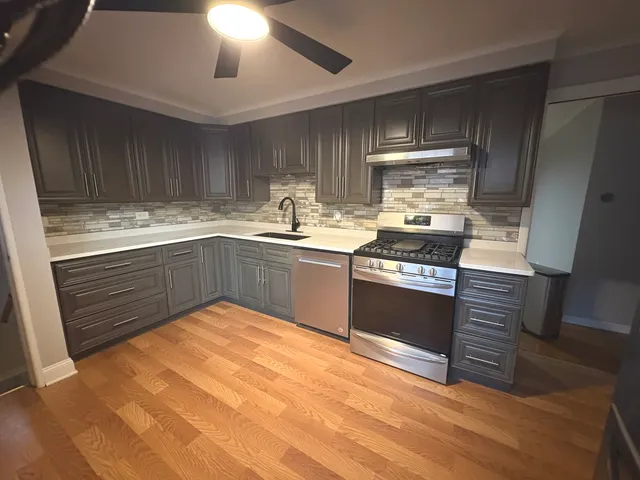 a kitchen with stainless steel appliances granite countertop a sink stove and refrigerator