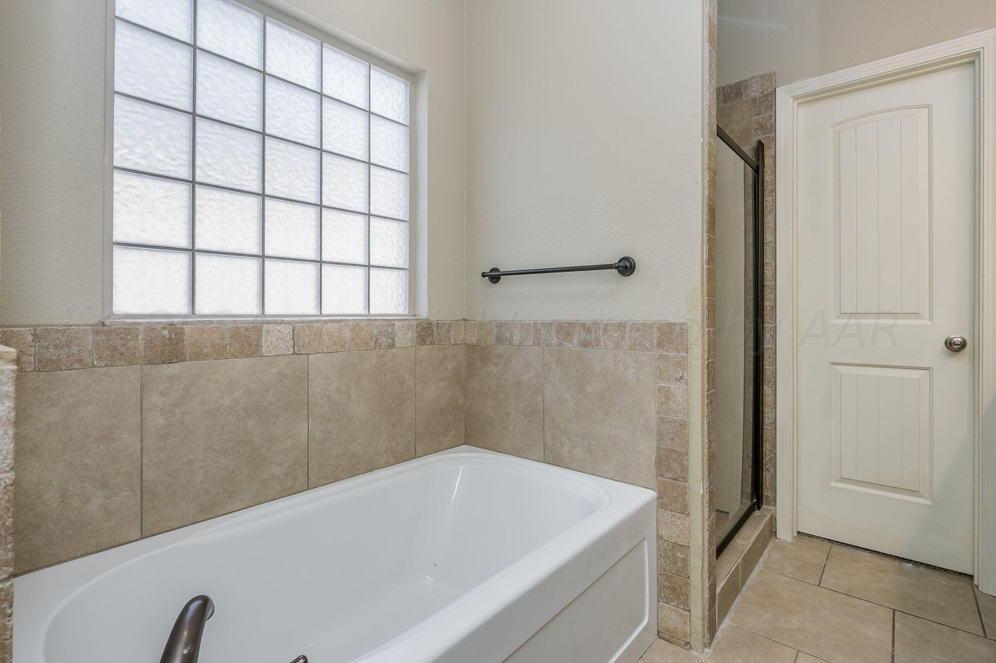 3601 Springfield Avenue Amarillo, TX 79118 - Photo 13 of 26 a bathroom with a bathtub and next to a window