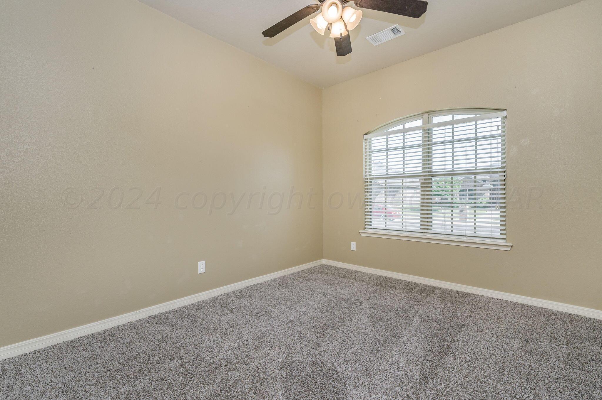 3601 Springfield Avenue Amarillo, TX 79118 - Photo 18 of 26 an empty room with a chandelier fan and windows