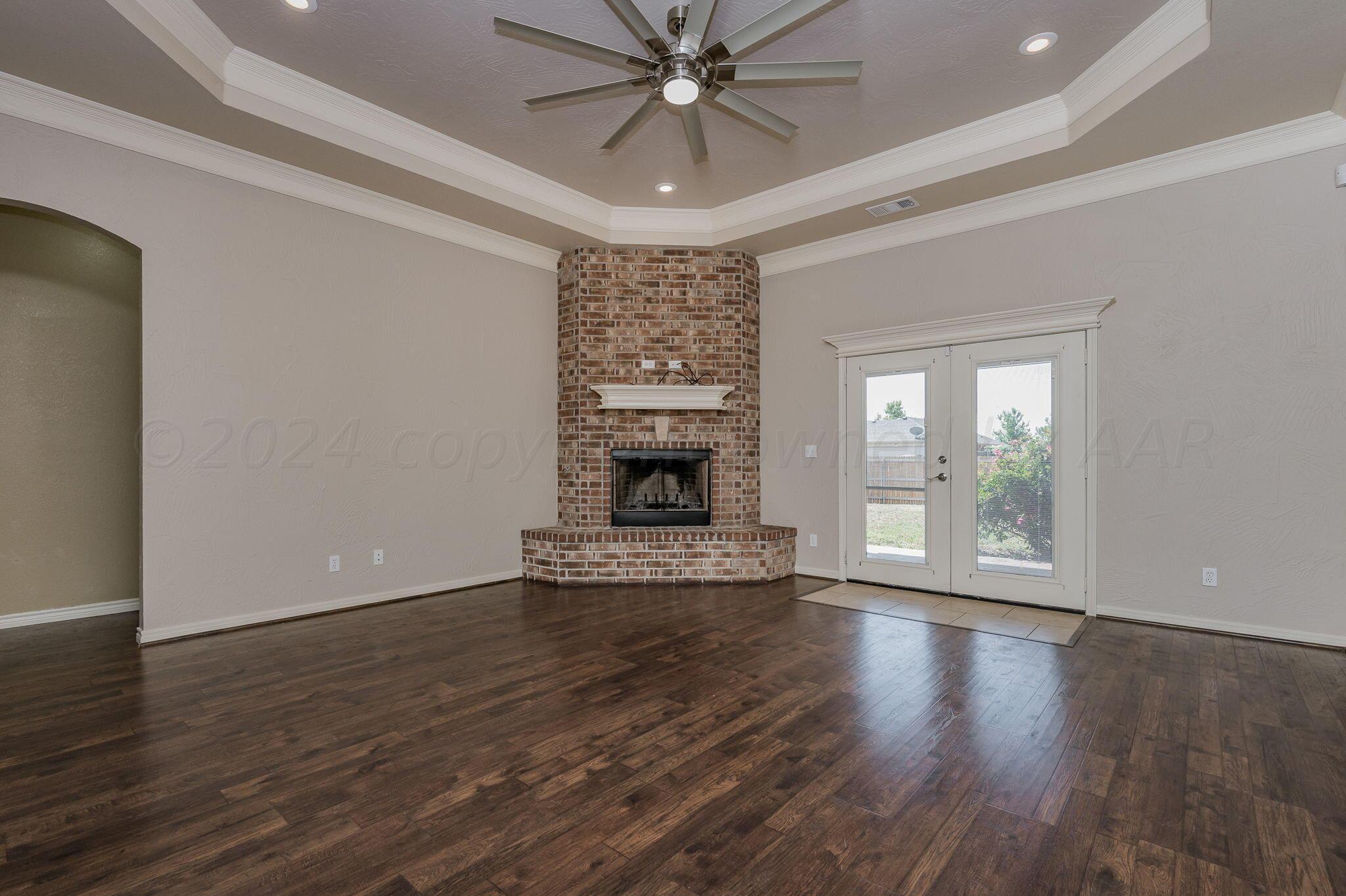 3601 Springfield Avenue Amarillo, TX 79118 - Photo 3 of 26 a view of an empty room with wooden floor fireplace and a window