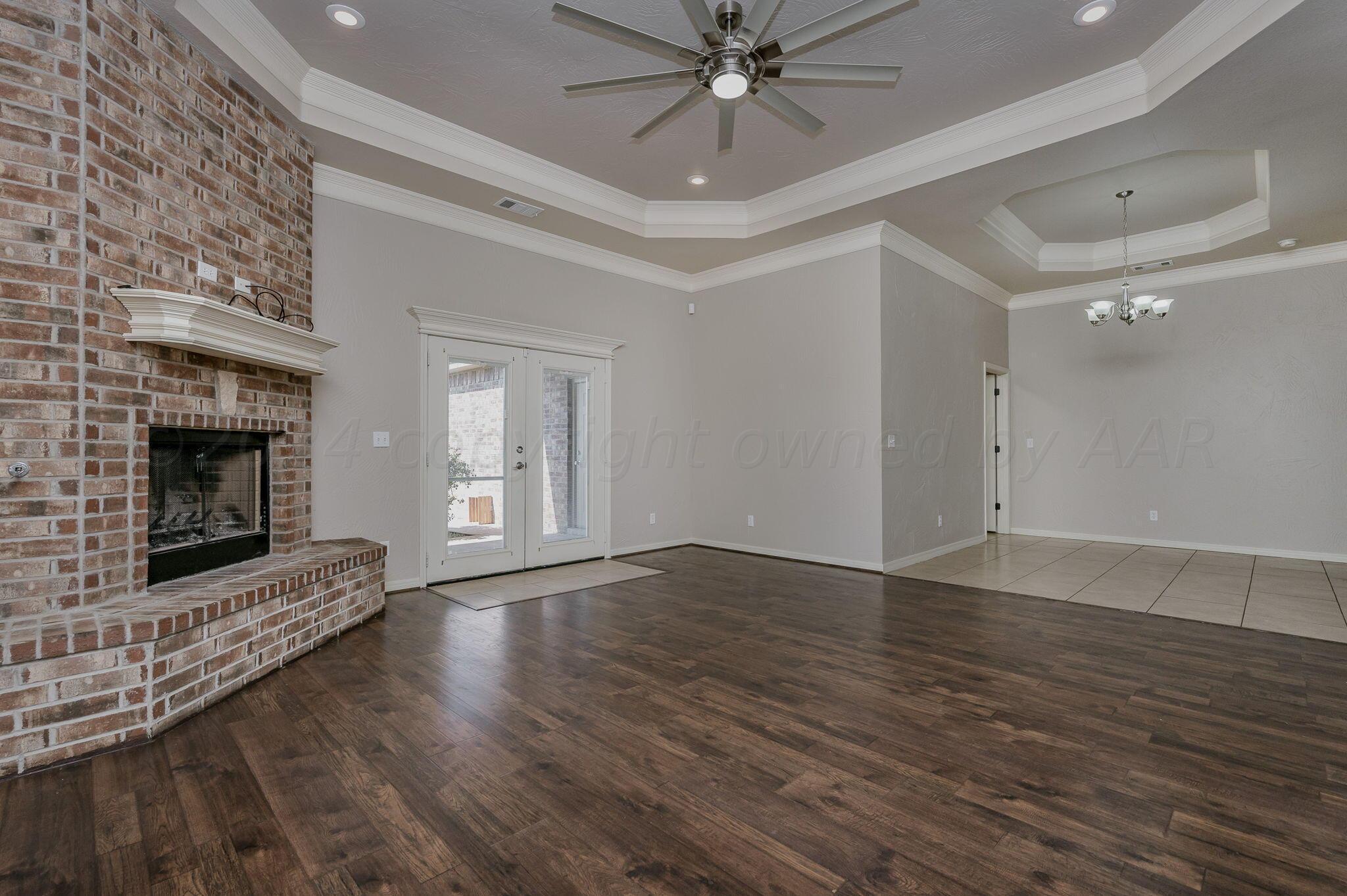 3601 Springfield Avenue Amarillo, TX 79118 - Photo 4 of 26 a view of an empty room with wooden floor fireplace and a window
