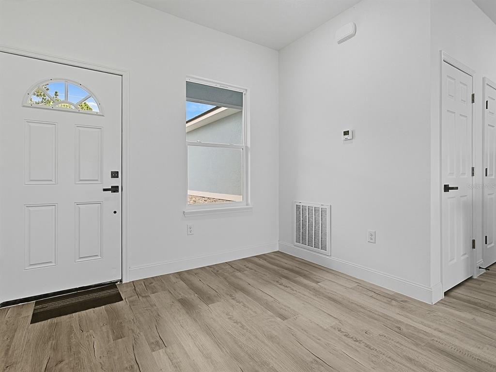 13322 Southwest 85th Circle Ocala, FL 34473 - Photo 11 of 27 an empty room with wooden floor and windows