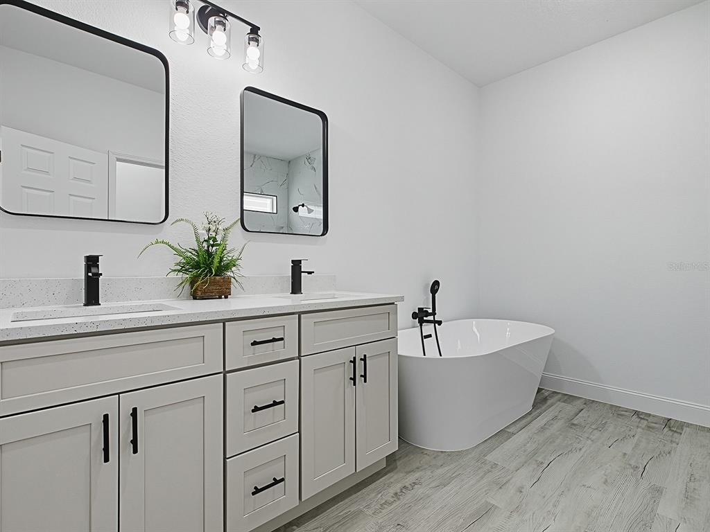 13322 Southwest 85th Circle Ocala, FL 34473 - Photo 14 of 27 a spacious bathroom with double vanity sinks a mirror and lamp