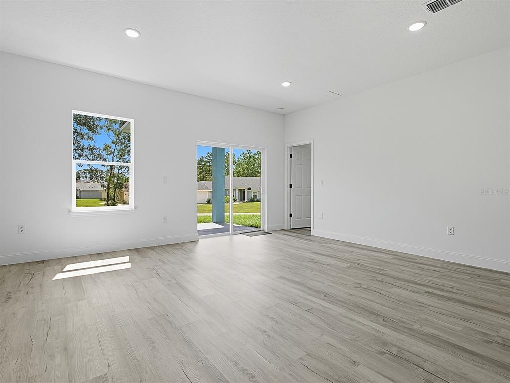 13322 Southwest 85th Circle Ocala, FL 34473 - Photo 20 of 27 an empty room with wooden floor and windows