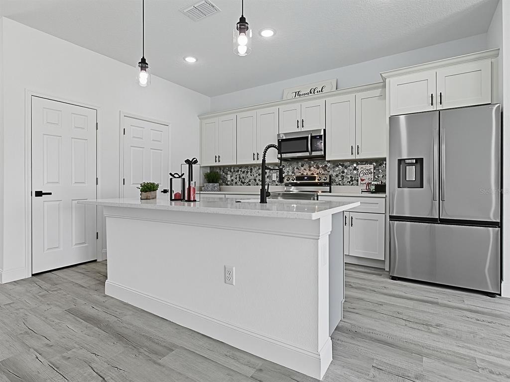 13322 Southwest 85th Circle Ocala, FL 34473 - Photo 2 of 27 a kitchen with stainless steel appliances a refrigerator sink and microwave