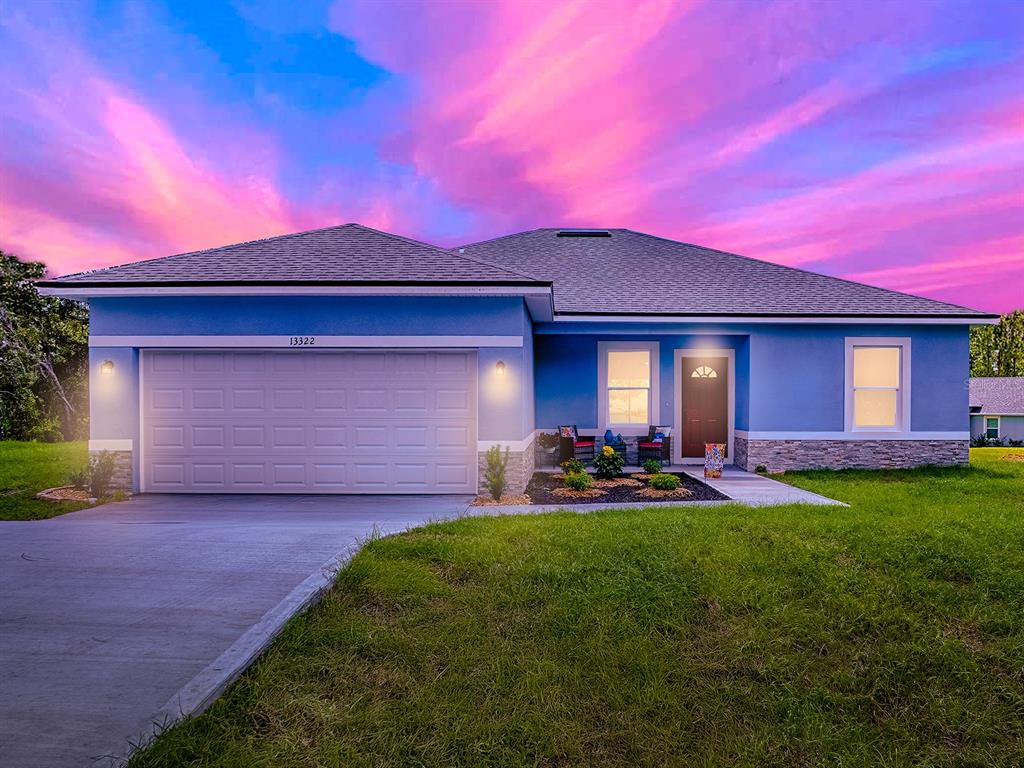 13322 Southwest 85th Circle Ocala, FL 34473 - Photo 3 of 27 a front view of a house with patio and garden