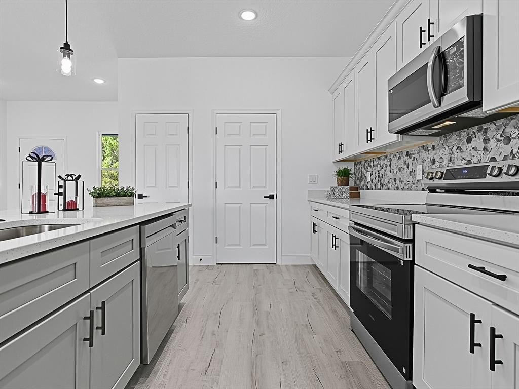 13322 Southwest 85th Circle Ocala, FL 34473 - Photo 10 of 27 a kitchen with white cabinets stainless steel appliances and sink