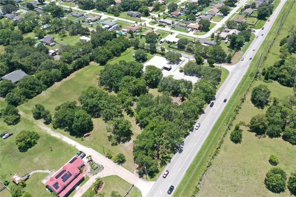 an aerial view of residential house with outdoor space and trees all around