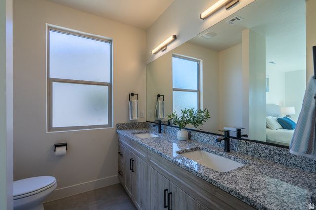 2972 West 570 North Hurricane, UT 84737 - Photo 53 of 104 Full bath featuring double vanity, ensuite bathroom, dark tile patterned floors, and plenty of natural light