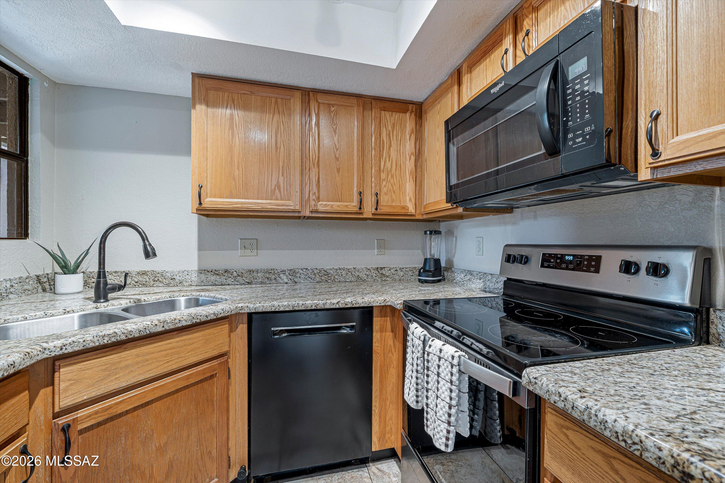 5800 North Kolb Road, Unit 5125 Tucson, AZ 85750 - Photo 10 of 34 a kitchen with stainless steel appliances granite countertop a stove and a microwave