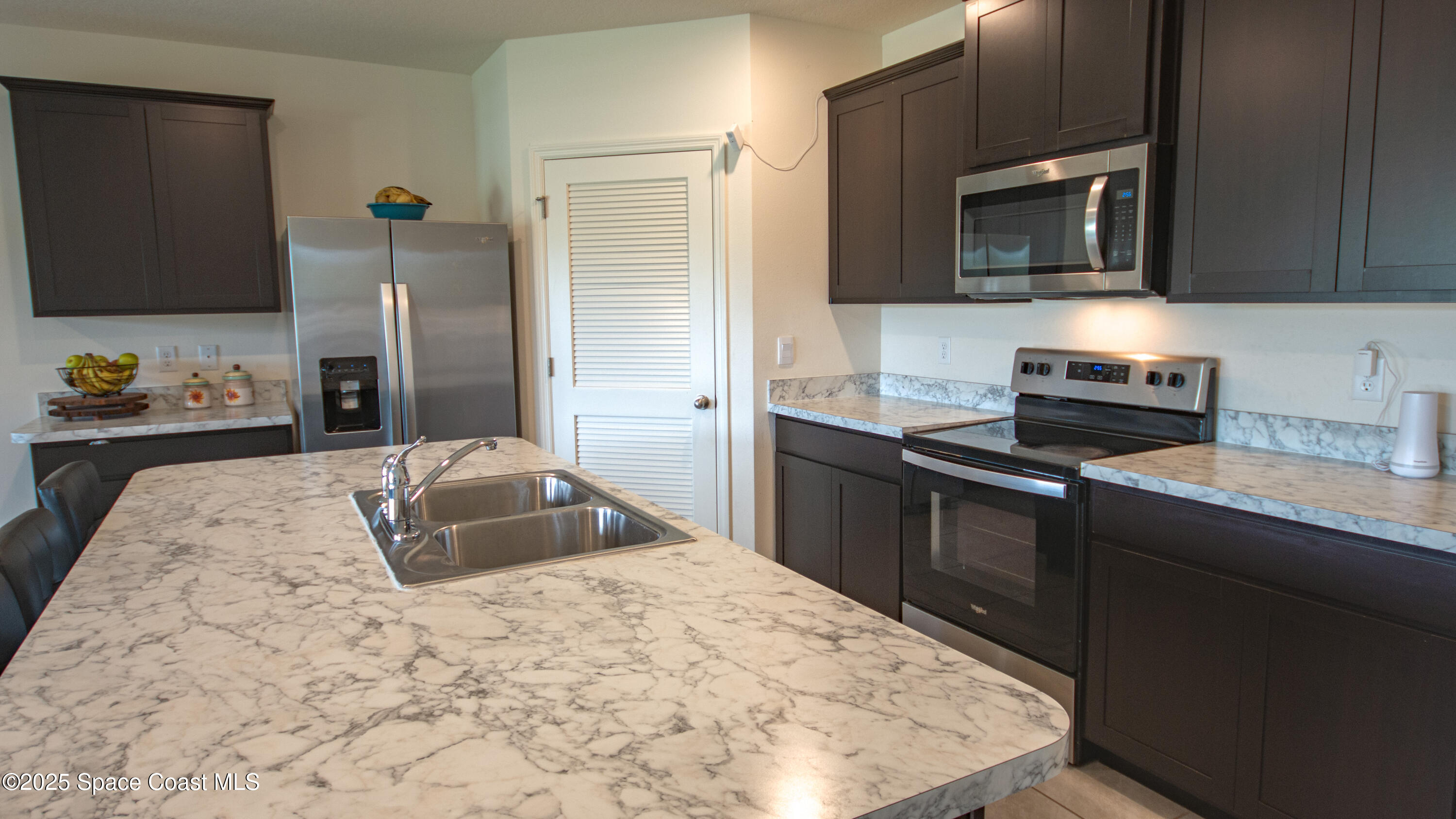 913 Trinity Street Rockledge, FL 32955 - Photo 10 of 25 a kitchen with kitchen island granite countertop a sink stove and microwave