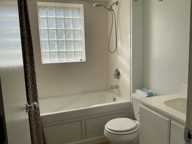a bathroom with a granite countertop toilet a sink and a shower