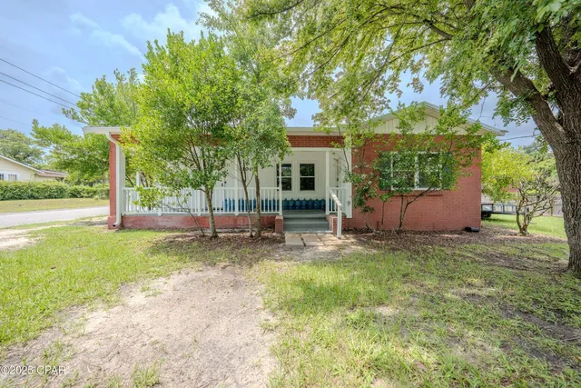 a view of a house with backyard and a tree