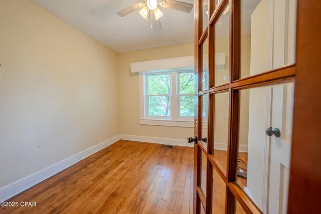 a view of hallway with a large window and wooden floor