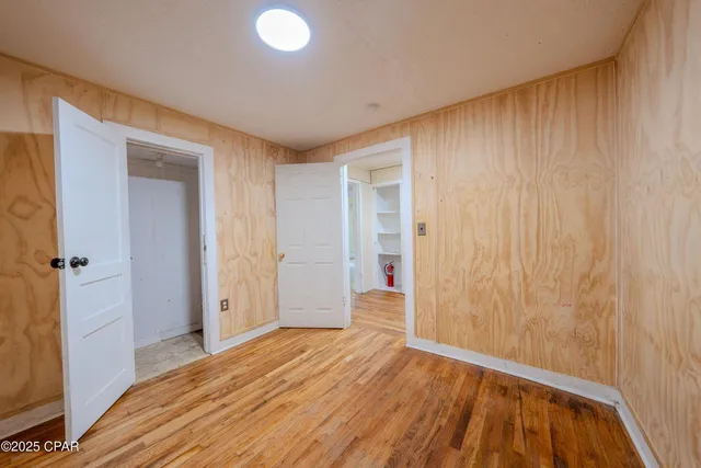 a view of a hallway with wooden floor and closet area