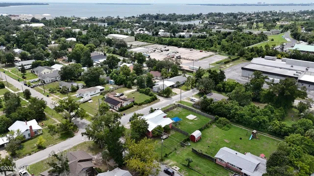an aerial view of residential houses with outdoor space and trees