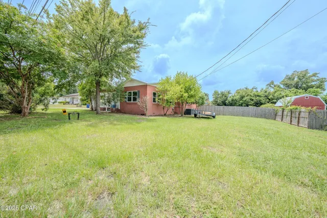 a view of a house with a yard and tree s