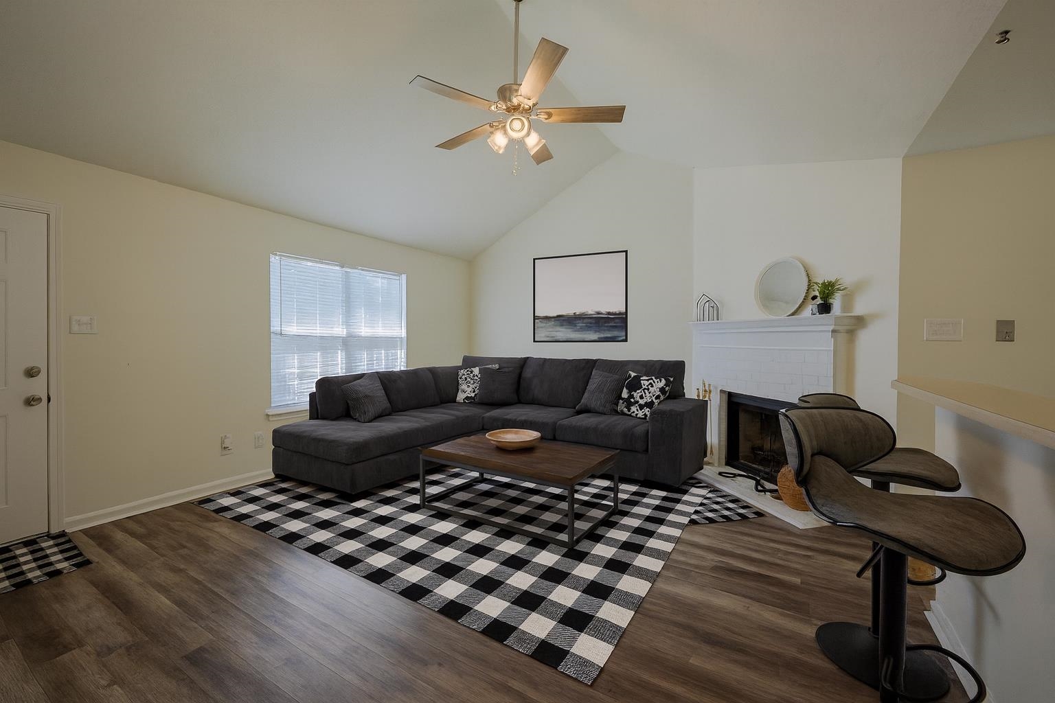 6876 Lagrange Hill Road Cordova, TN 38018 - Photo 3 of 28 Living area with lofted ceiling, dark wood-style floors, a fireplace, and ceiling fan. This image has been virtually staged.