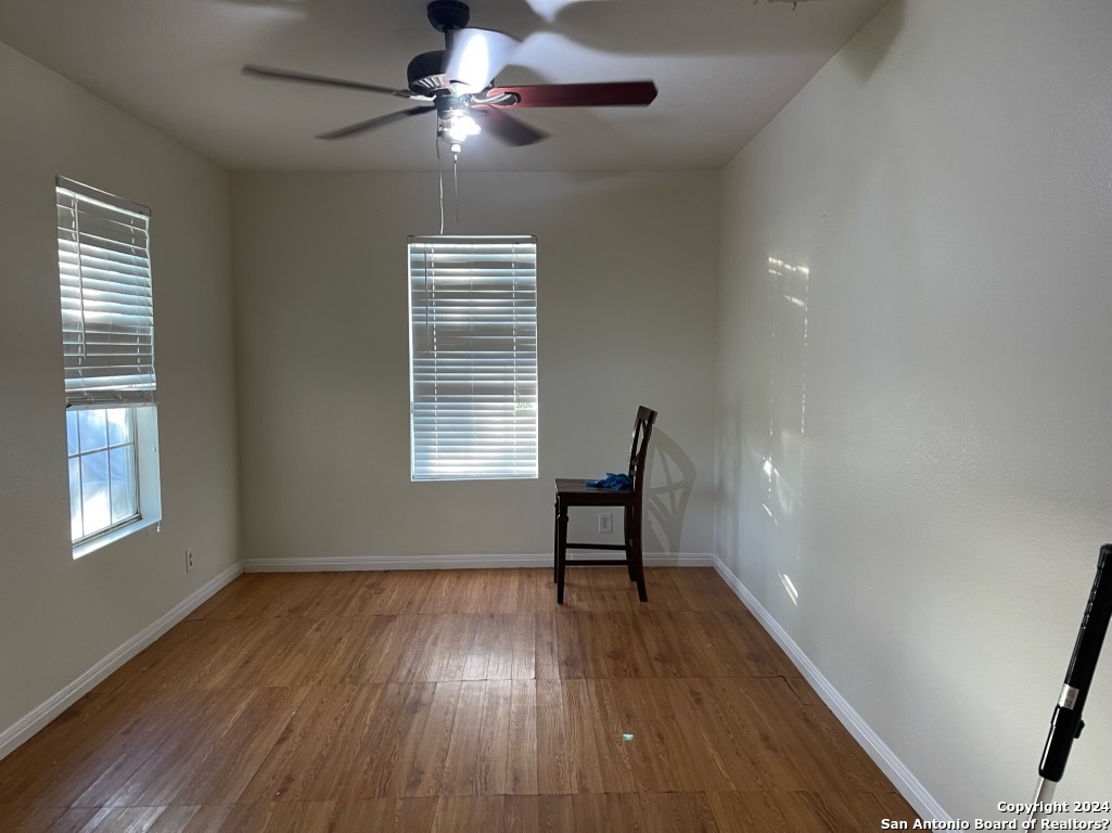 a view of room with a ceiling fan hardwood and windows
