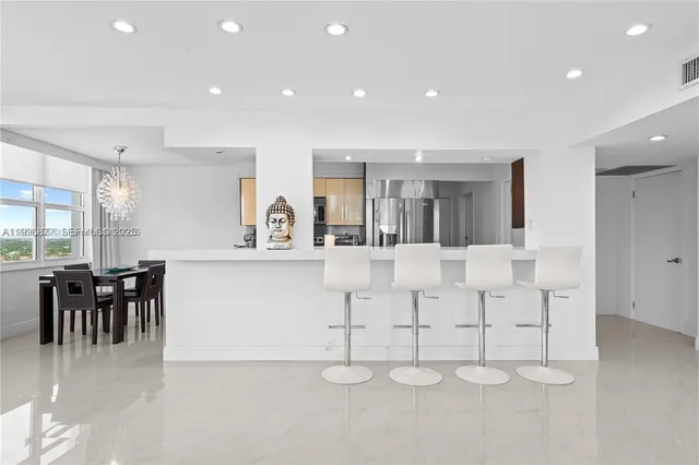 an open kitchen with white cabinets and dining table