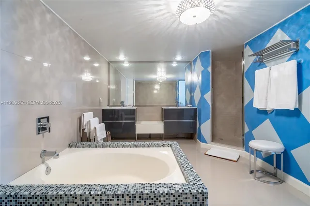 a bathroom with a tub a sink and a mirror