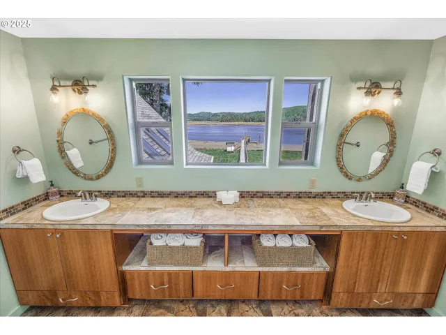 a bathroom with a granite countertop sink a mirror and wooden floor