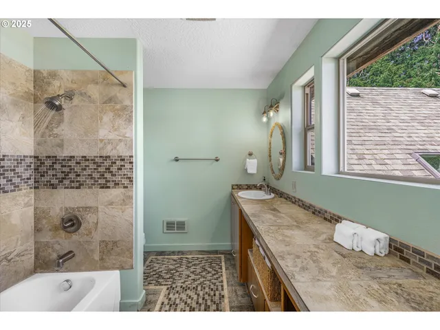 a bathroom with a granite countertop sink a mirror and a bathtub