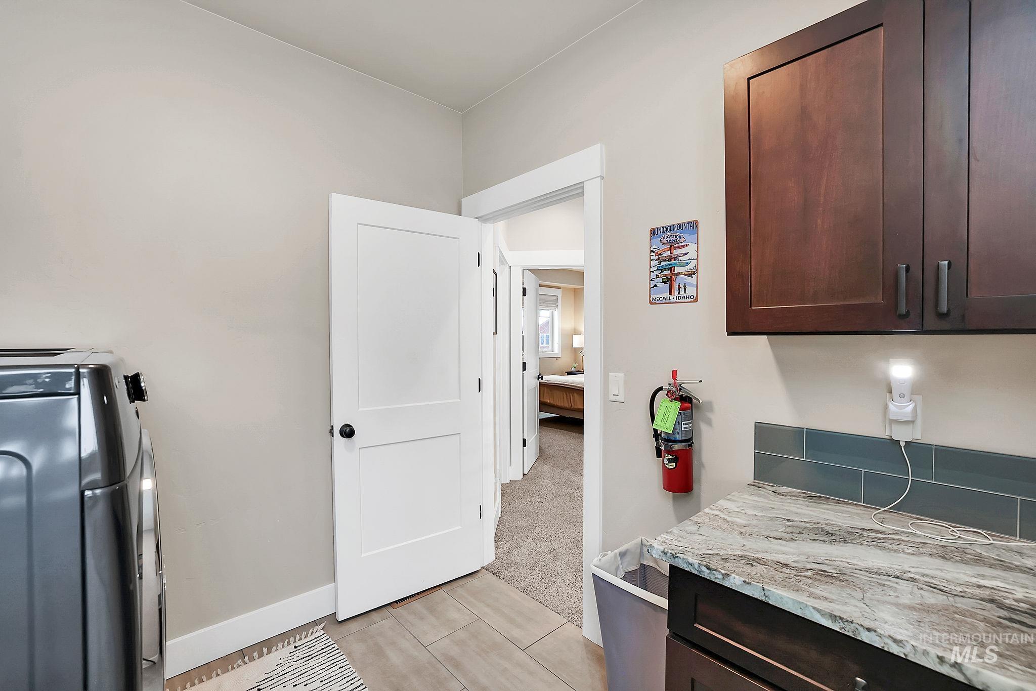 609 Blue Water Circle McCall, ID 83638 - Photo 32 of 45 Laundry room with washer / clothes dryer, light carpet, and light tile patterned floors