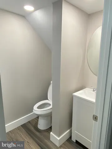 a white toilet sitting next to a white sink and vanity