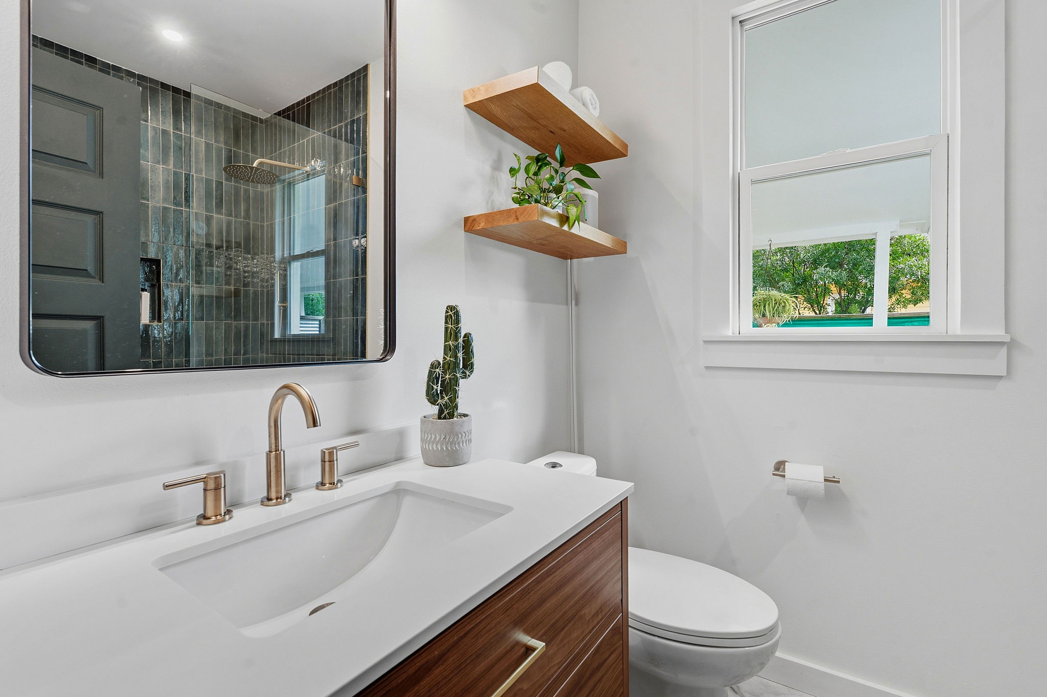 1122 Gunter Street Austin, TX 78702 - Photo 10 of 23 Bathroom featuring a vanity with a white countertop and a rectangular sink, a wall-mounted mirror, and a window providing natural light