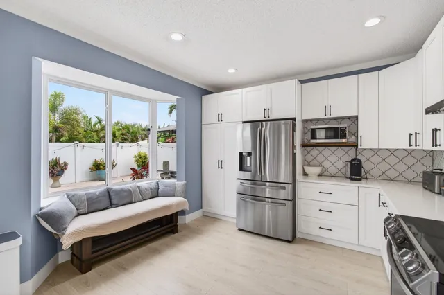 a kitchen with white cabinets and stainless steel appliances