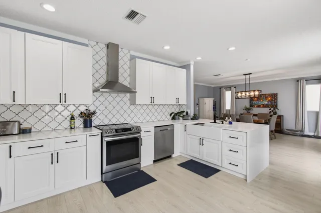 a kitchen with white cabinets and stainless steel appliances