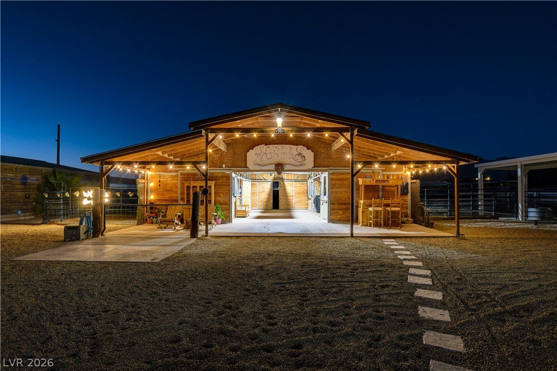 6460 Racel Street Las Vegas, NV 89131 - Photo 4 of 59 An illuminated rustic wood barn stands under a deep twilight sky.